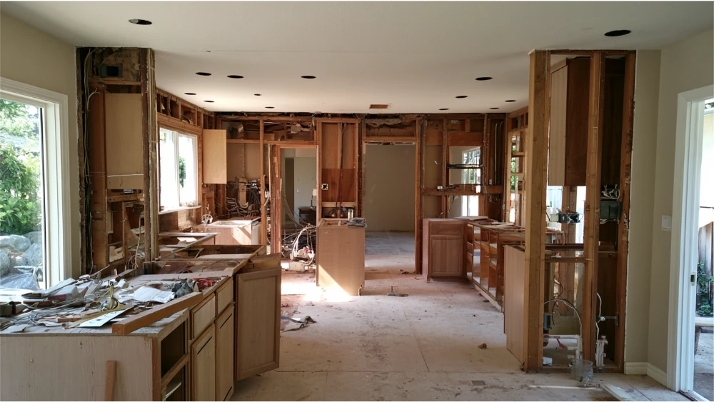 Kitchen renovation with exposed walls showing plumbing and electrical systems during remodeling
